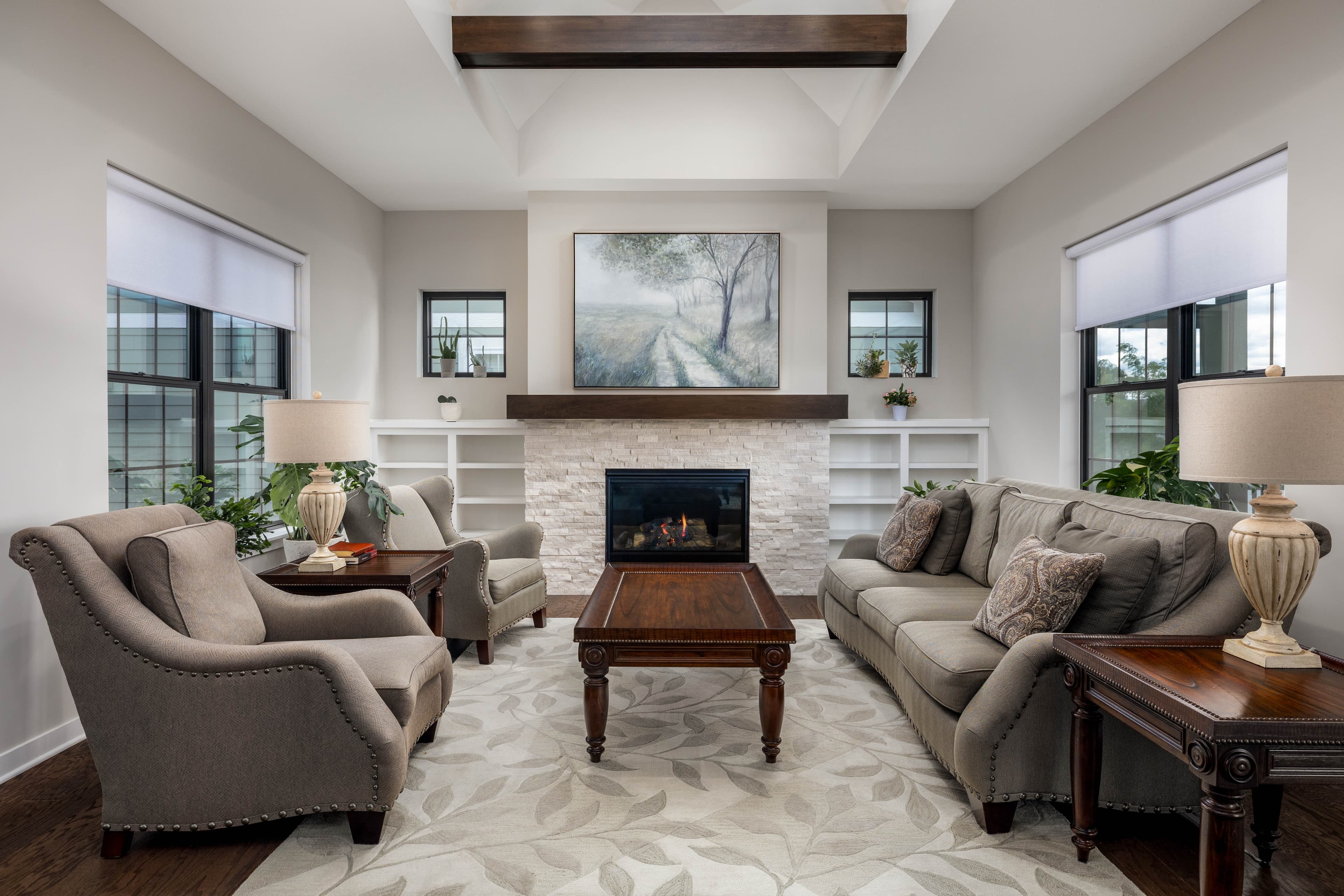 Symmetrical living room with fireplace, built-in shelving, and large windows